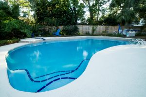 Bright blue pool in the backyard of a home.