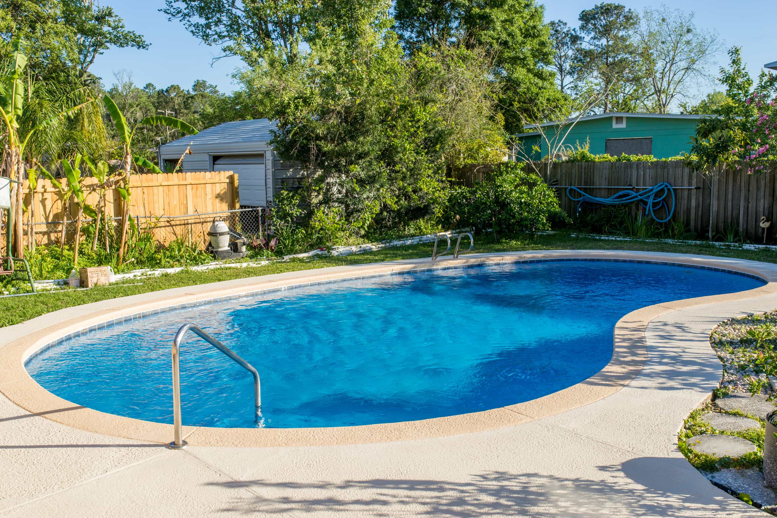 Bright blue pool in the backyard of a home.